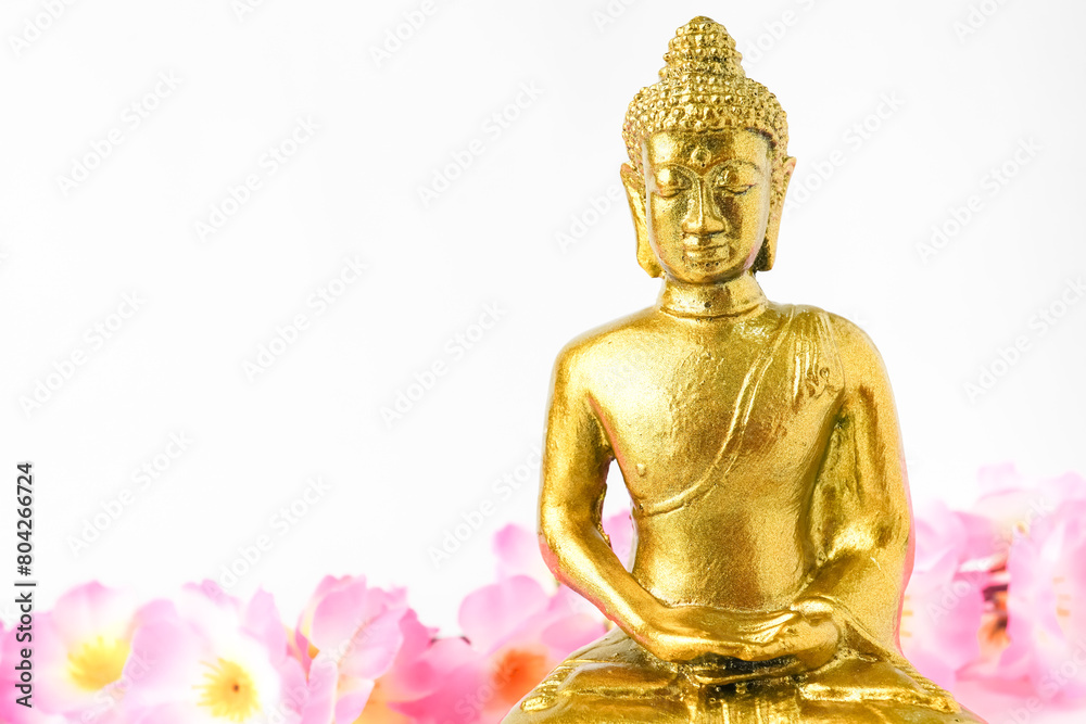 A golden statue of a Buddhist figure meditating decorate with colorful flowers facing the front isolated on white background. Concept for Vesak Day and Enlightenment Day A golden statue of a Buddhist figure meditating decorate with colorful flowers facing the front isolated on white background. Concept for Vesak Day and Enlightenment Day