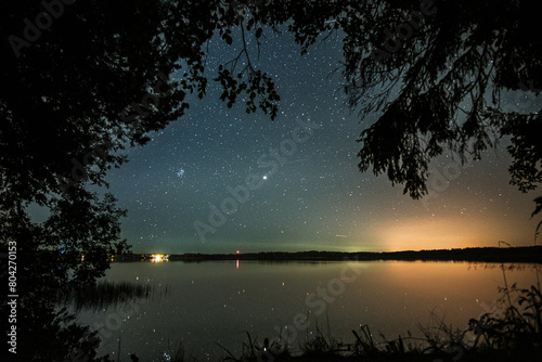 Valdai Lake against the background of the starry sky and the forest