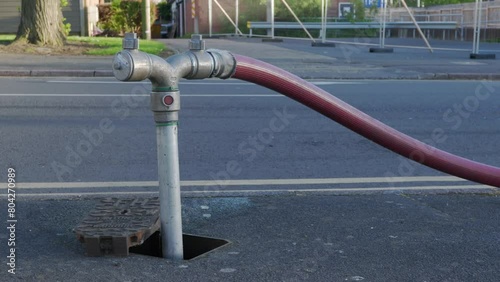 A well in a street has been opened and a fire hydrant connection point to supply water on road in england uk. photo