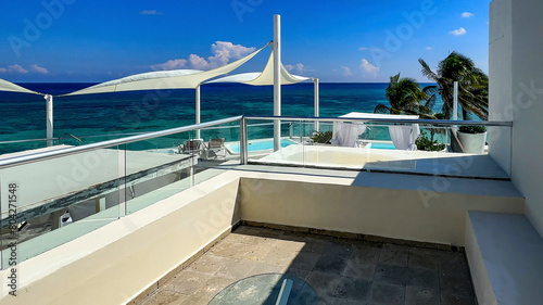 Terrace and relaxation area of a luxury Hotel Resort with the Caribbean landscape in the background typical of a beach of fine white sand and crystal clear turquoise water ideal for summer vacations.