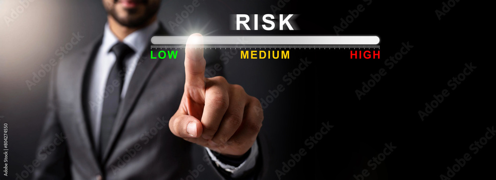Close-up of a businessman hand touching or pointing the risk management for financial investments, chart with text Low, Medium and High Risk. On a black background with copy space. Generative Ai. Close-up of a businessman hand touching or pointing the risk management for financial investments, chart with text Low, Medium and High Risk. On a black background with copy space. Generative Ai.