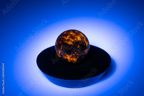 natural yooperlite gem stone in uv light on the white background photo