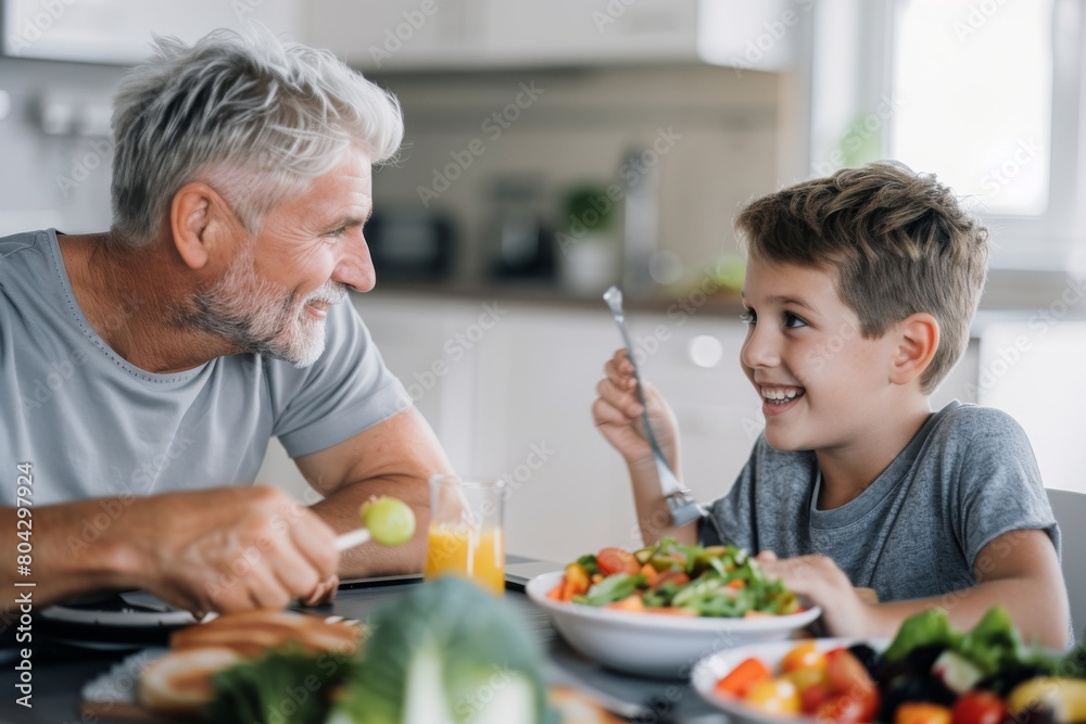 Father having food with son at dining table in house Father having food with son at dining table in house
