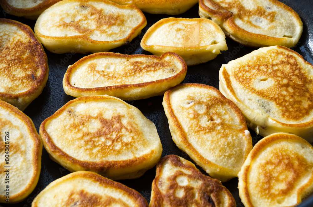 Homemade pancakes are fried in a frying pan. Delicious pancakes with a golden crust.