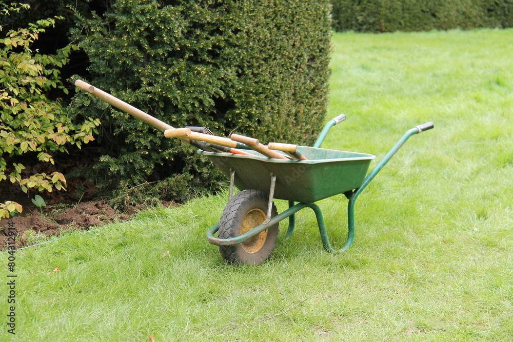 A Gardeners Wheelbarrow with a Collection of Tools. A Gardeners Wheelbarrow with a Collection of Tools.