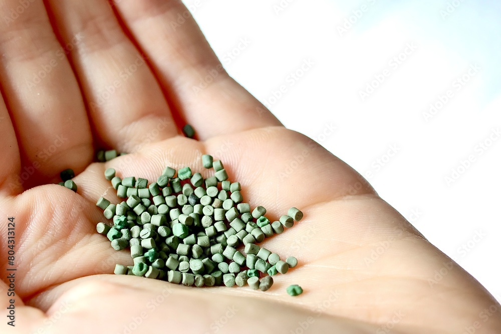 Recycling von Kunststoff und Plastik für Umweltschutz und gegen Mikroplastik symbolisiert durch eine Hand, die grünes Plastikgranulat hält Recycling von Kunststoff und Plastik für Umweltschutz und gegen Mikroplastik symbolisiert durch eine Hand, die grünes Plastikgranulat hält