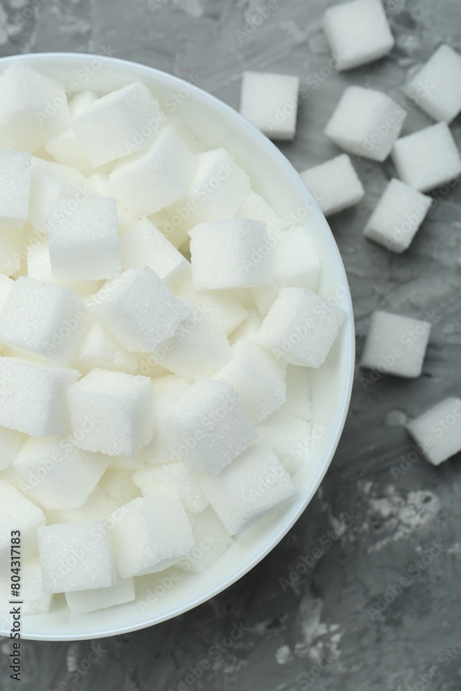 White sugar cubes in bowl on grey table, top view