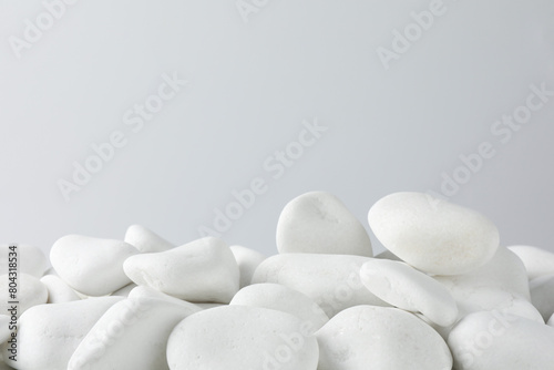 Presentation for product. White pebbles on light background. Space for text