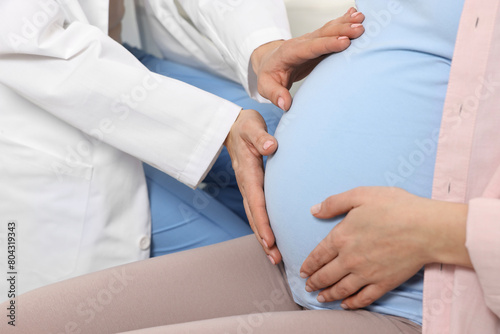Pregnancy checkup. Doctor examining patient s tummy in clinic  closeup