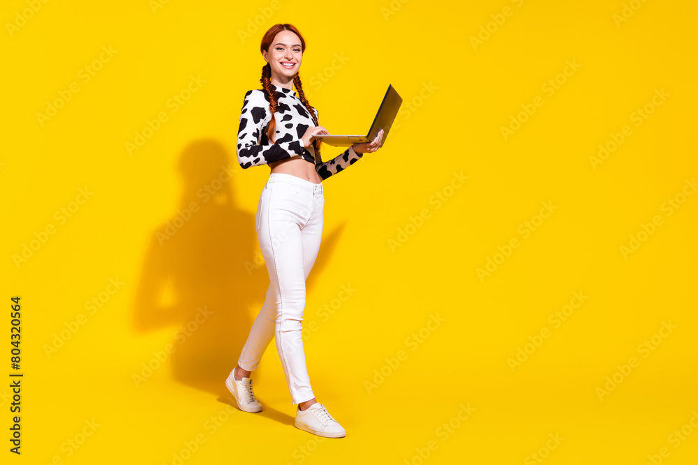 Full length photo of good mood shiny woman wear cow skin print top texting emails modern gadget isolated yellow color background Full length photo of good mood shiny woman wear cow skin print top texting emails modern gadget isolated yellow color background