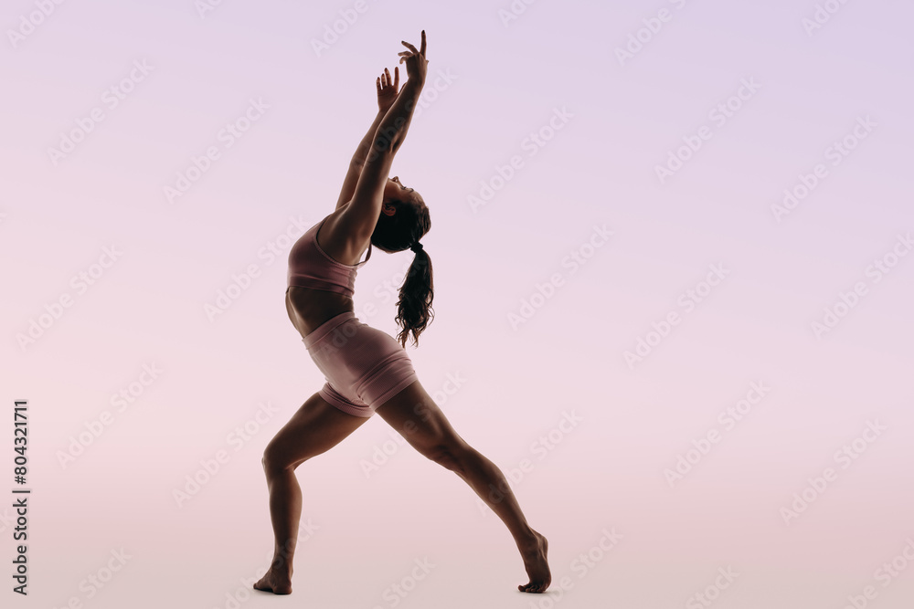 Athletic ballerina demonstrates artistic dance routine with flexibility and form Athletic ballerina demonstrates artistic dance routine with flexibility and form