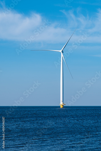A solitary wind turbine stands tall in the vast ocean, harnessing the power of the wind to generate clean energy for a sustainable future
