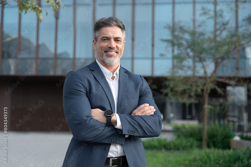 © Stock 4 You - Smiling confident latin hispanic mature business man standing crossed arms on busy city street. Proud portrait of older senior businessman professional ceo, coach, leader looking at camera near office © Stock 4 You - Smiling confident latin hispanic mature business man standing crossed arms on busy city street. Proud portrait of older senior businessman professional ceo, coach, leader looking at camera near office