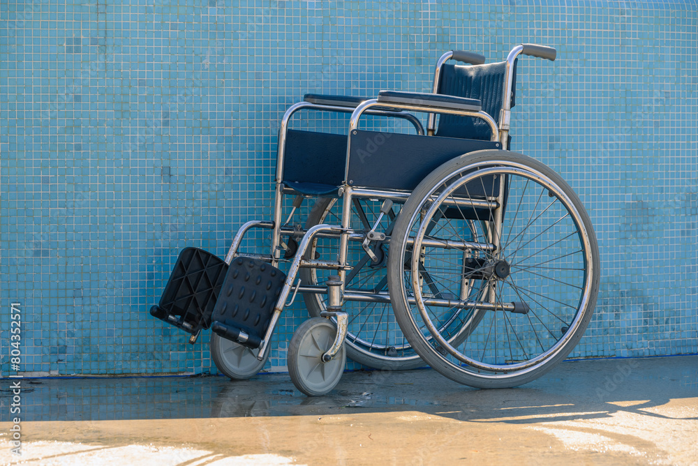 Empty wheelchair at accessible pool for assistance to help people with disabilities.