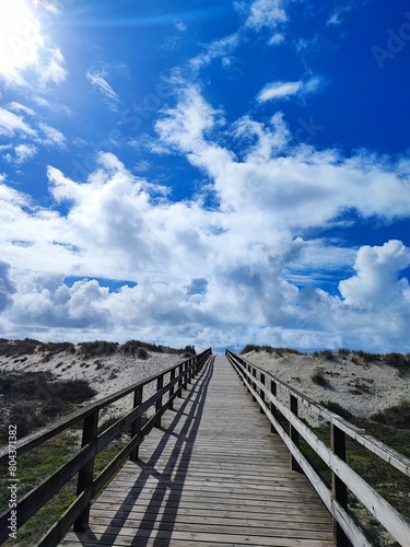 Path along a wooden flooring, a path in Portugal for pilgrims along the ocean coast on a sunny day