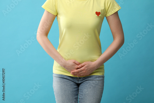 Wallpaper Mural Woman suffering from cystitis on light blue background, closeup Torontodigital.ca