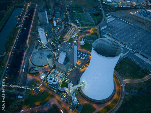 Aerial drone view of the Duisburg Walsum power station at night, a coal-fired thermal power station with a 300m high chimney, and energy infrastructure in Germany, close to the cooling tower. Iconic