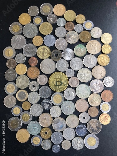 View of bitcoin symbol surrounding with coins from all over the world