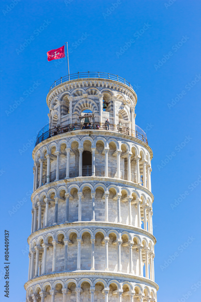 Traditional Pisan Cross flag on top of the leaning tower in Pisa, Italy