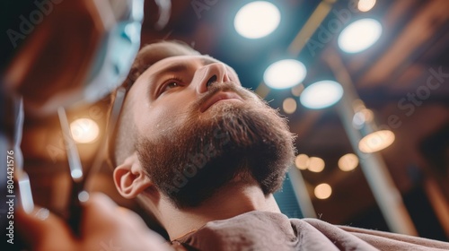 Man with a thick beard getting a haircut in a barbershop