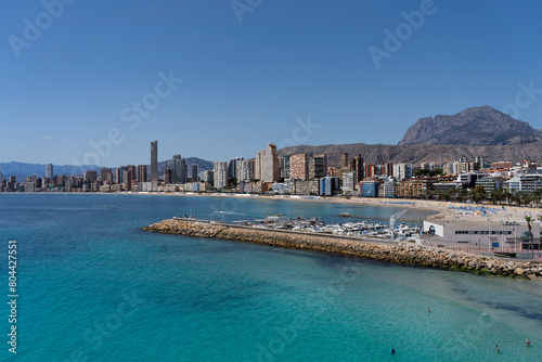 Panorama of Benidorm including the breakwater, small marina, local beach and the majestic Puig Campana mountain in the background. photo