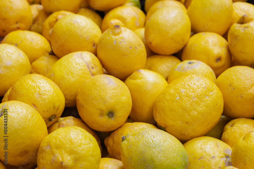 Lemons on the market. Juicy lemons background. Yellow fruits. Heap of ripe lemons. Yellow color background. Citrus harvest. Healthy eating. Vitamins and antioxidant. Lemons on the market. Juicy lemons background. Yellow fruits. Heap of ripe lemons. Yellow color background. Citrus harvest. Healthy eating. Vitamins and antioxidant.