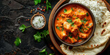 Delicious homemade chicken tikka masala curry with freshly baked naan bread on dark background