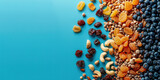 Assorted dried fruits and nuts on blue background with copy space, top view flat lay concept for healthy snack
