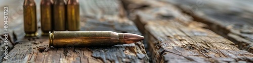 Rifle cartridges. Ammunition for weapons on a wooden surface. Dark background.