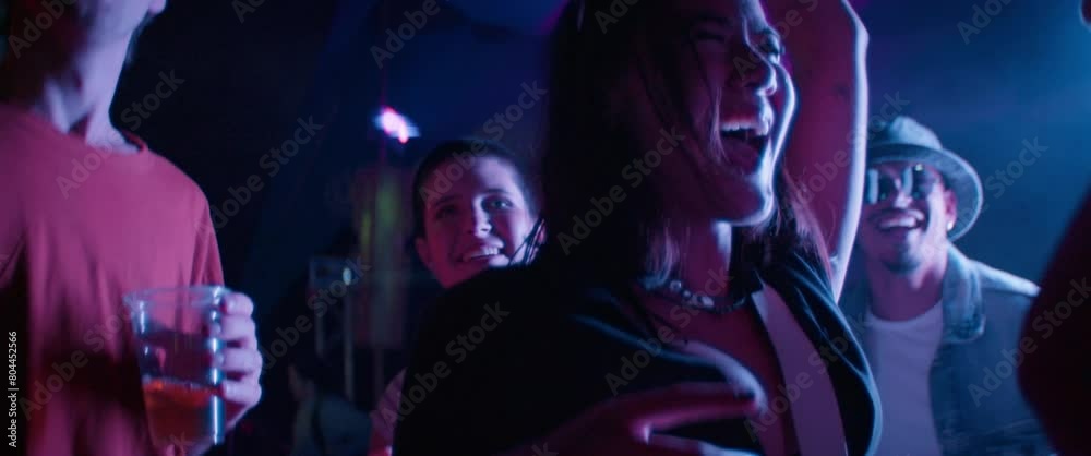 Diverse group of young adults dancing happily at music festival