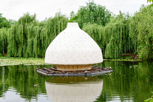 Big Chinese light lantern situated in the center of the lake of Alexandru Buia Botanical Garden from Craiova in Dolj county, Romania, in a spring day with white clouds photo