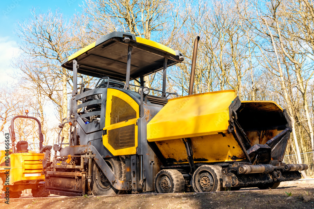 Yellow asphalt paver filled tarmac laying new road building site Yellow asphalt paver filled tarmac laying new road building site