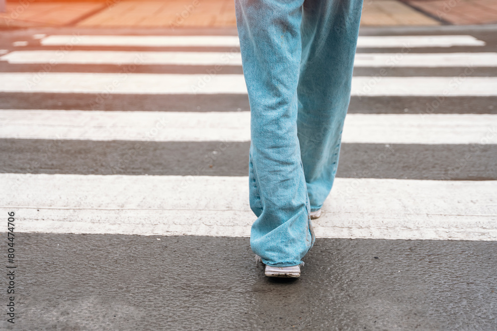 legs of woman in jeans crossing road on pedestrian zebra crossing Lifestyle people