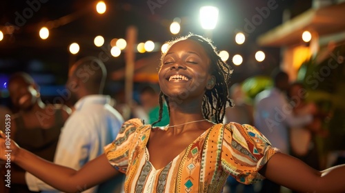 A young woman is dancing at a party, surrounded by friends and music. She is happy and carefree, and she is enjoying the moment. photo
