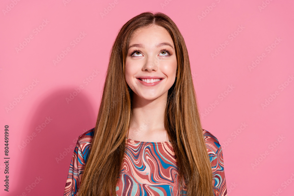 Photo of positive cheerful girl with straight hairdo dressed print shirt look up at sale empty space isolated on pink color background Photo of positive cheerful girl with straight hairdo dressed print shirt look up at sale empty space isolated on pink color background