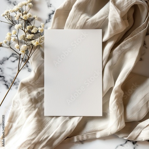 Blank paper card mockup on beige linen fabric and marble background.