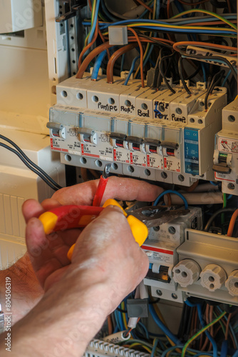Obraz na płótnie An electrician works on a fuse box w salonie
