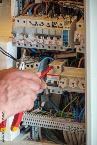 An electrician works on a fuse box