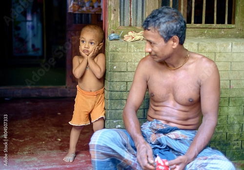 Bangladeshi rural grandfather and grandson in front of their house 
