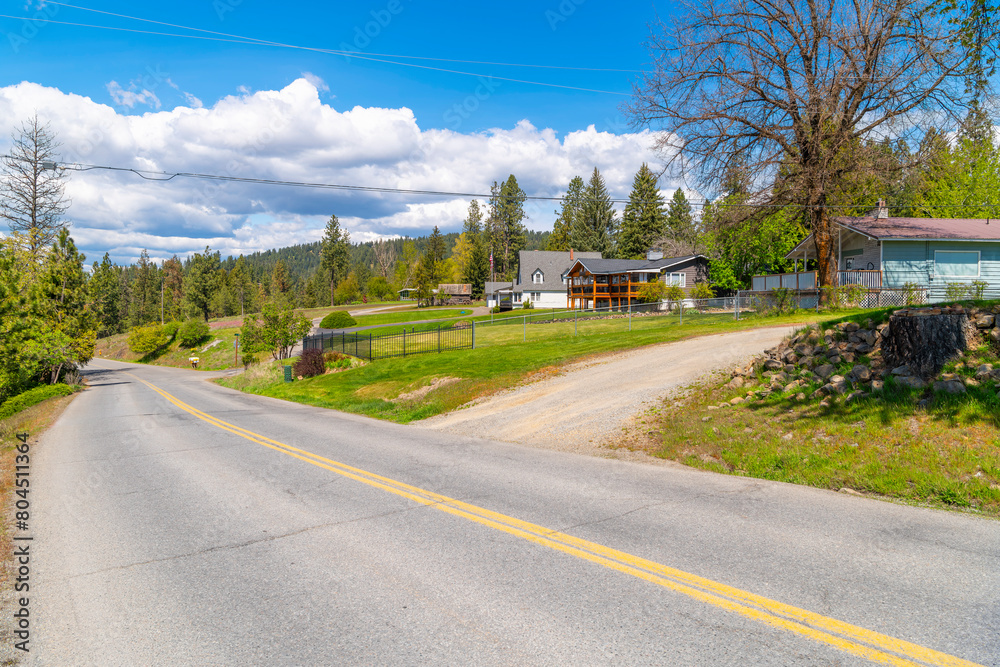 A curving hillside street of ranch homes in a rural mountain section of downtown Coeur d'Alene, Idaho USA. A curving hillside street of ranch homes in a rural mountain section of downtown Coeur d'Alene, Idaho USA.