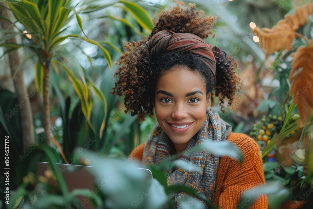 Happy young woman with curly hair in a botanical setting