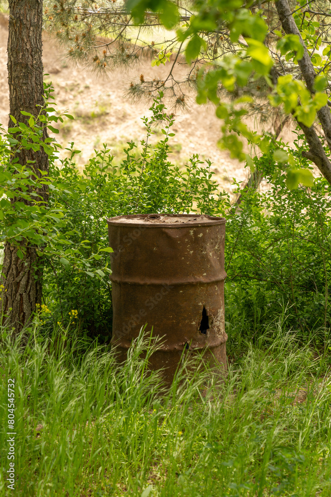 A rusty barrel is sitting in a field of grass. The barrel is old and rusted, and it is surrounded by tall grass. The scene is peaceful and quiet, with the only sounds being the rustling of the grass A rusty barrel is sitting in a field of grass. The barrel is old and rusted, and it is surrounded by tall grass. The scene is peaceful and quiet, with the only sounds being the rustling of the grass
