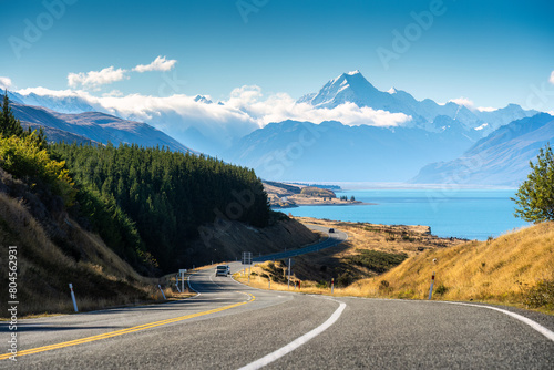 Scenic road trip of Mt Cook over winding road and Lake Pukaki on sunny day at New Zealand