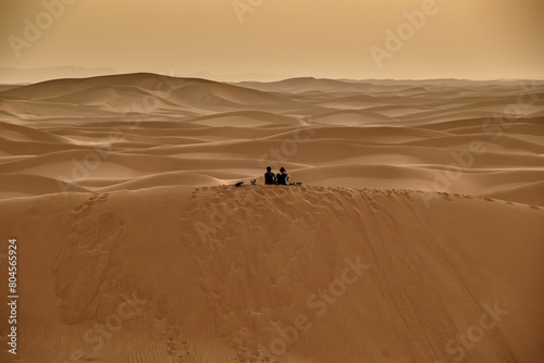 Casal a contemplar o deserto e as dunas do Saara em Marrocos photo