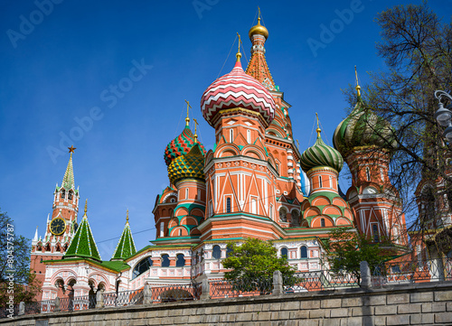 Cathedral of the Intercession of the Blessed Virgin Mary on the Moat (St. Basil's Cathedral) on Red Square in Moscow. Against the background of the Spasskaya Tower of the Kremlin.  photo