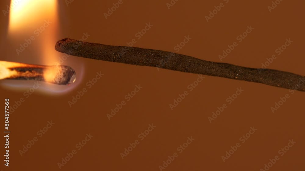 To light incense stick with a match. Smoke from incense burning. To light incense stick with a match. Smoke from incense burning.