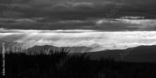 Landscape with a mountain range and the rays of the sun breaking through the storm clouds
