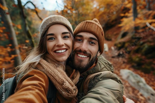 Romantic couple taking selfie in autumn forest park