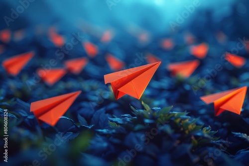 A singular orange paper plane leads the way as it stands out against multiple blue paper planes in a conceptual image photo