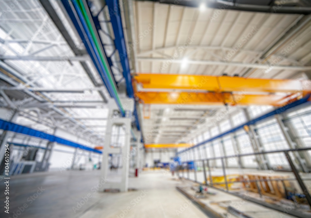 Fototapeta premium the blurred background of the factory interior , a modern light metalworking hangar warehouse with equipment